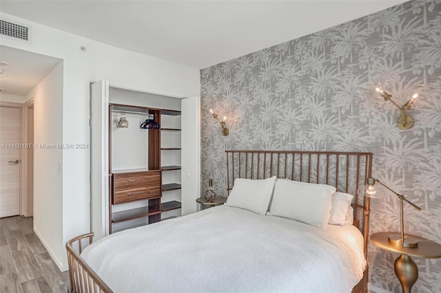 801 S Miami Ave Unit 2509, Miami, FL 33130 - bedroom with wallpapered walls, wood finished floors, a closet, and an accent wall