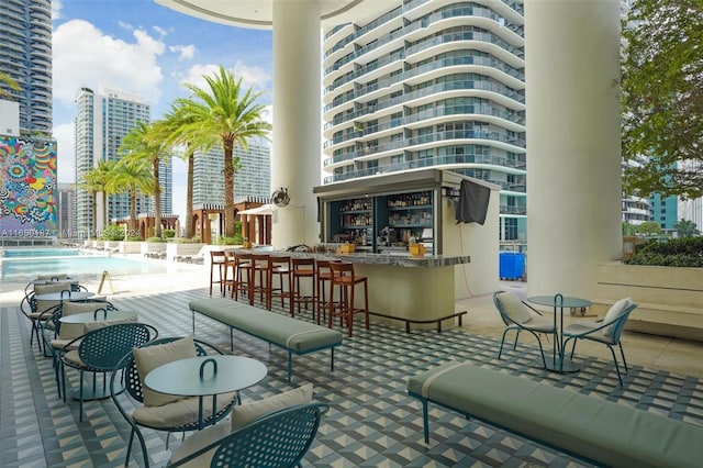 view of patio featuring a community pool and an outdoor bar