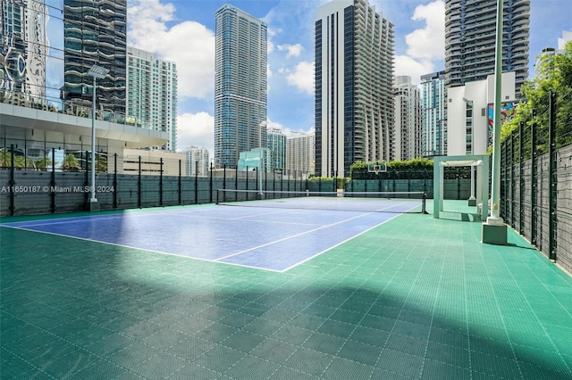 view of tennis court with basketball hoop