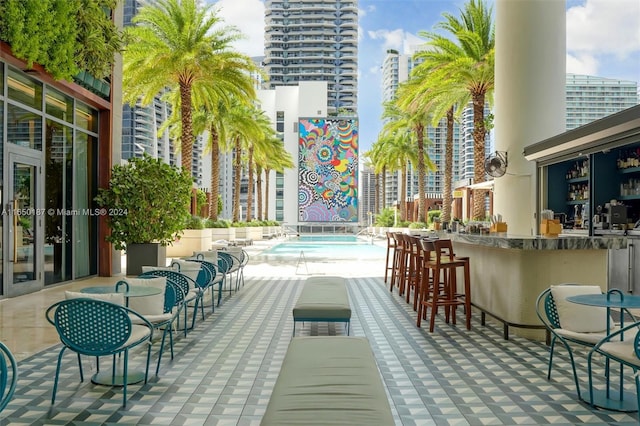 view of patio with an outdoor bar and a community pool