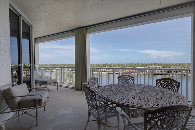 sunroom / solarium featuring plenty of natural light and a water view