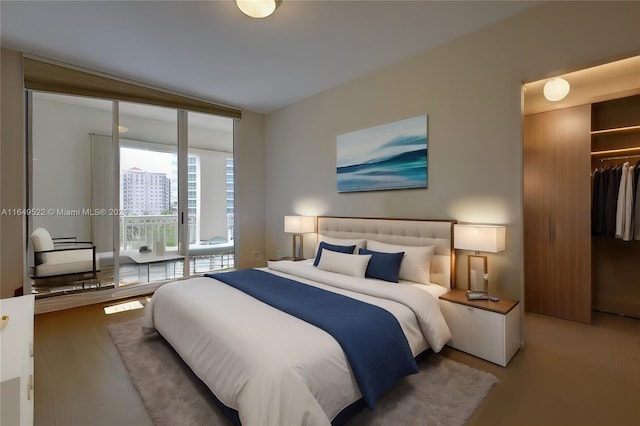 bedroom featuring access to exterior, a closet, and wood finished floors