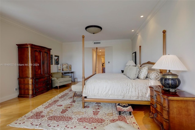 bedroom with crown molding and light hardwood / wood-style floors