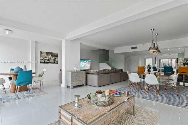 living room with beamed ceiling and tile patterned floors