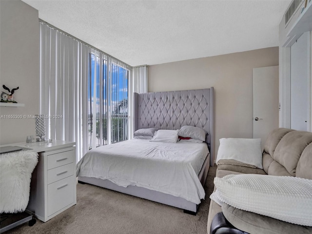 bedroom with a textured ceiling and light colored carpet