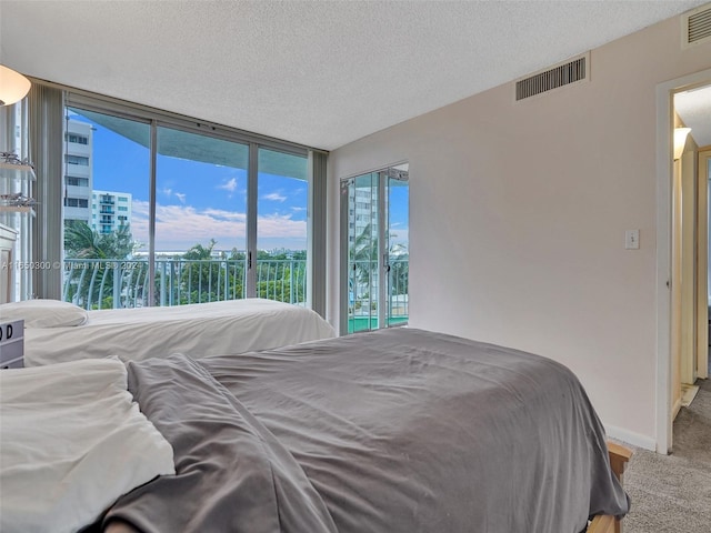 bedroom featuring a textured ceiling, carpet flooring, and access to exterior