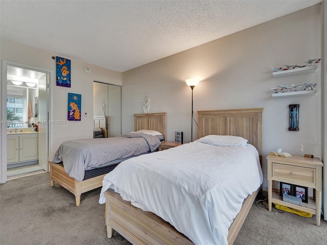 bedroom with ensuite bath, a closet, a textured ceiling, and carpet floors