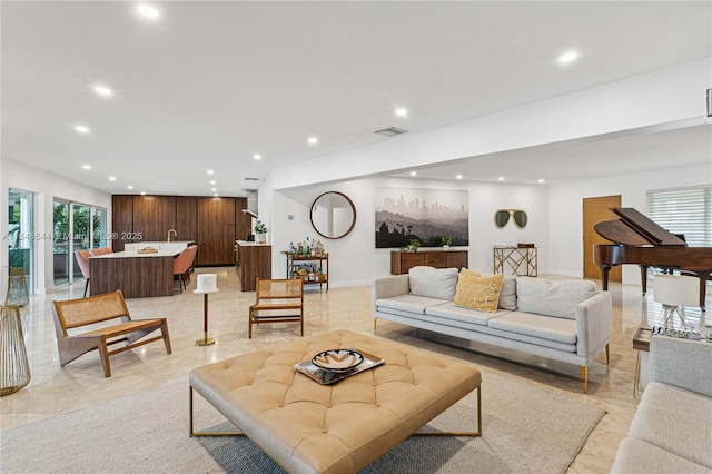 living area with baseboards, visible vents, and recessed lighting