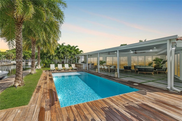 view of pool with a fenced in pool, outdoor lounge area, fence, a deck, and ceiling fan