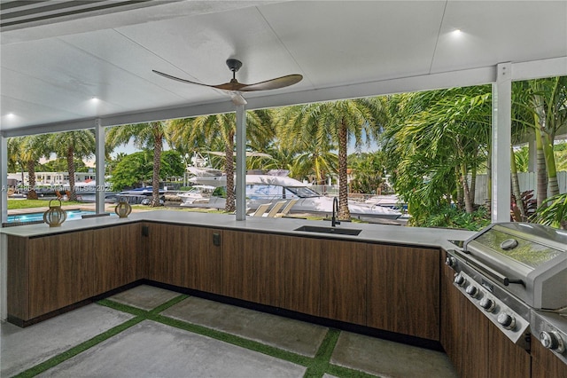 unfurnished sunroom featuring a ceiling fan and a sink