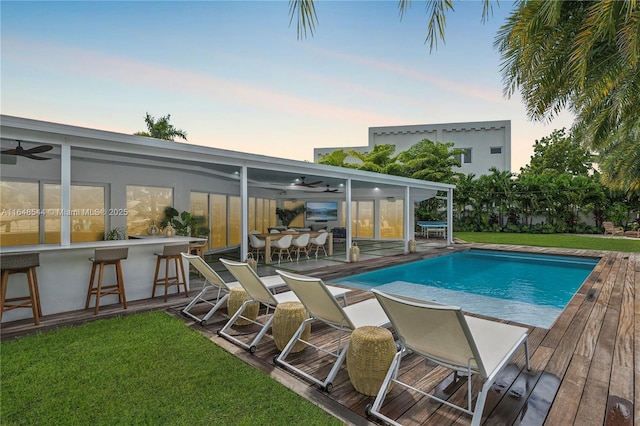 outdoor pool featuring outdoor dry bar and a yard