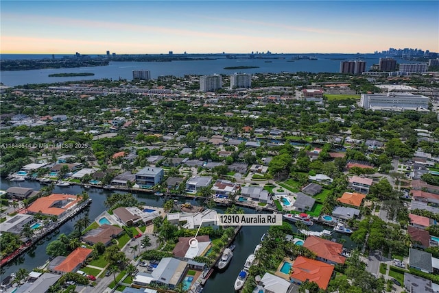 aerial view at dusk featuring a water view