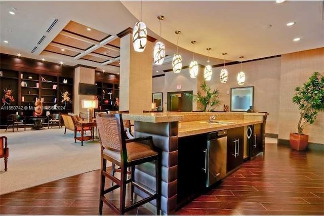 bar with a high ceiling, dishwasher, dark hardwood / wood-style flooring, sink, and hanging light fixtures