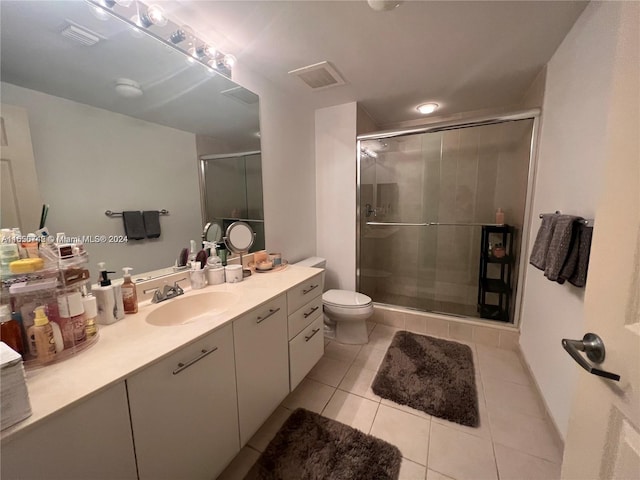 bathroom featuring vanity, toilet, an enclosed shower, and tile patterned floors