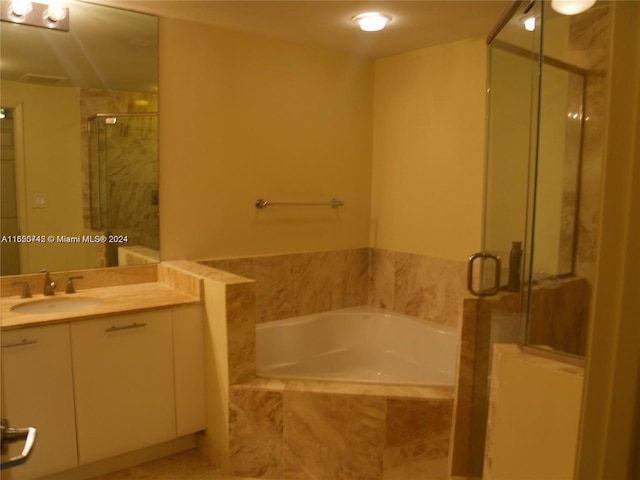 bathroom with vanity and independent shower and bath