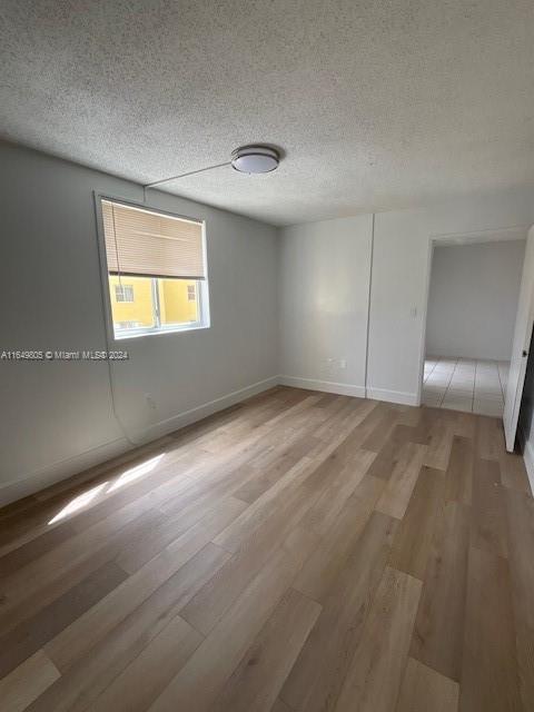 unfurnished bedroom featuring a textured ceiling and wood-type flooring