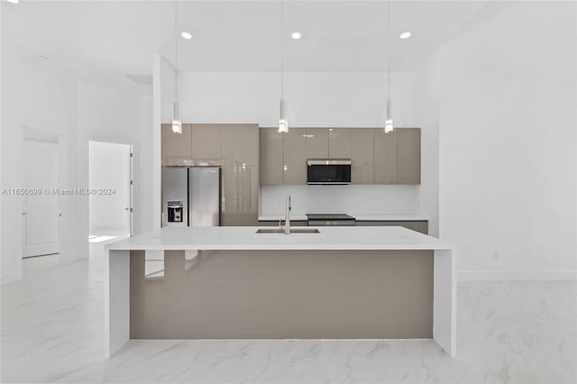 kitchen with gray cabinetry, sink, appliances with stainless steel finishes, and a center island with sink