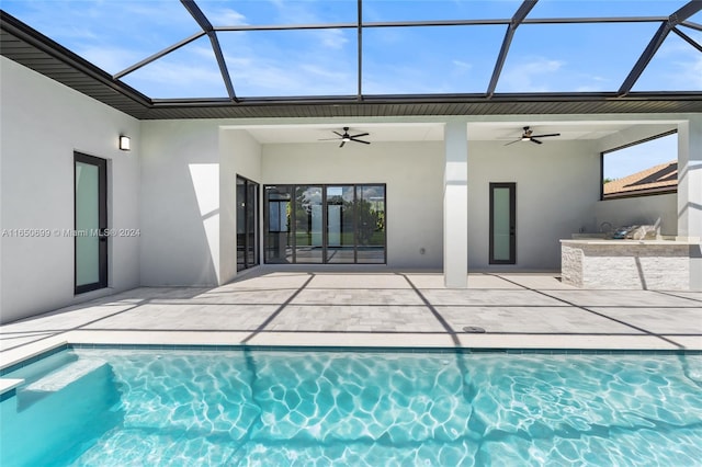 view of swimming pool with ceiling fan, a patio, and glass enclosure