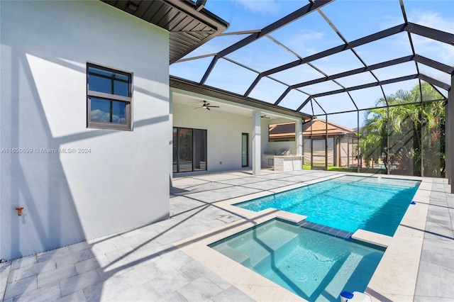 view of pool with glass enclosure, ceiling fan, and a patio area