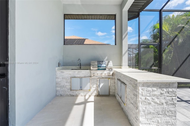 view of patio featuring an outdoor kitchen, a lanai, and sink