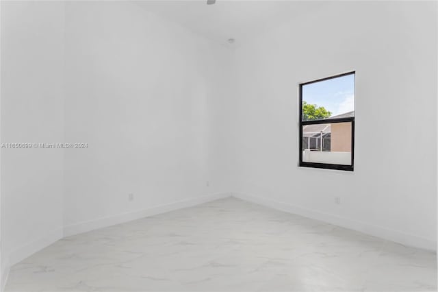 unfurnished room with lofted ceiling