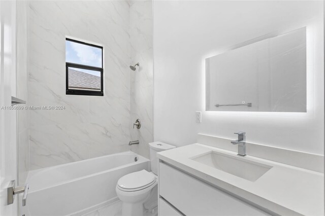 full bathroom featuring tiled shower / bath, toilet, and vanity