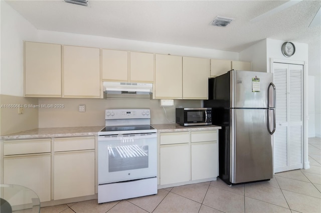 kitchen featuring visible vents, appliances with stainless steel finishes, cream cabinets, light countertops, and under cabinet range hood