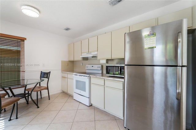 kitchen with light tile patterned floors, visible vents, stainless steel appliances, light countertops, and under cabinet range hood