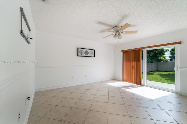 unfurnished room featuring light tile patterned floors, baseboards, a ceiling fan, and a textured ceiling