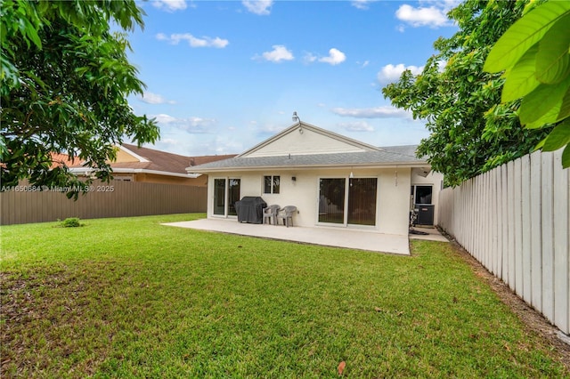 rear view of house with a patio area, a lawn, and a fenced backyard