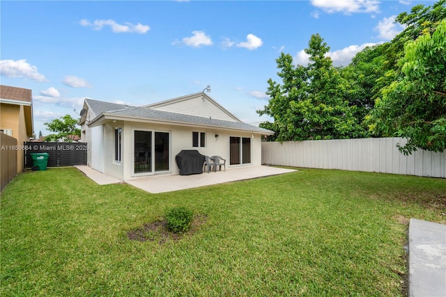 rear view of property featuring a patio area, a lawn, a fenced backyard, and stucco siding