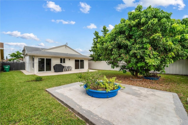 rear view of property featuring a yard, a fenced backyard, a patio, and stucco siding