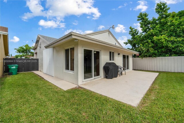 back of property featuring fence private yard, a lawn, a patio, and stucco siding