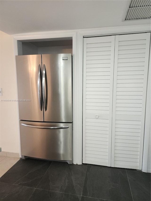 kitchen featuring dark tile patterned floors and stainless steel fridge