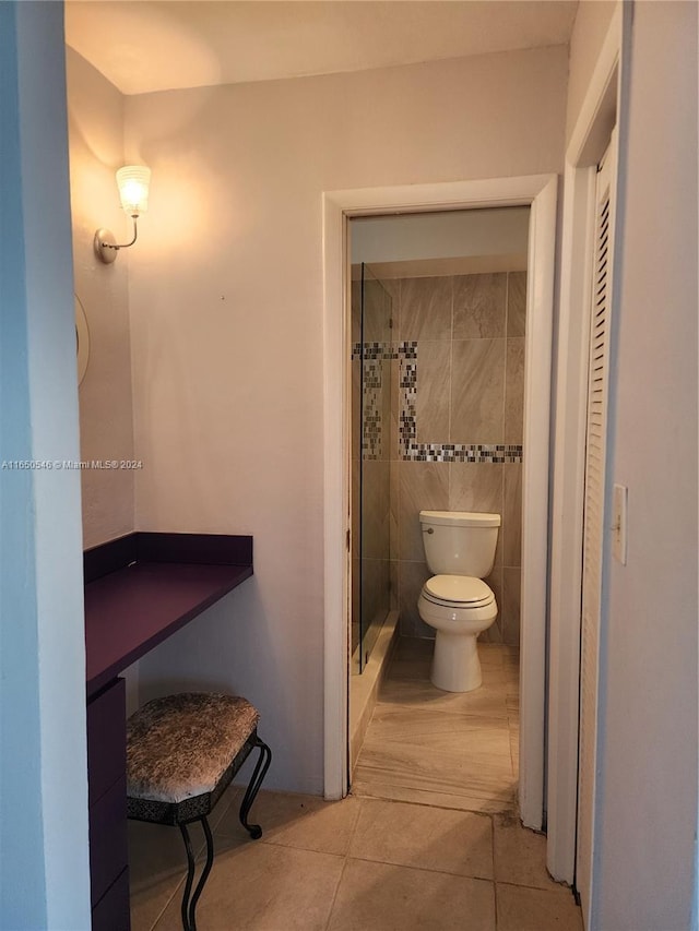 bathroom featuring tile patterned flooring, an enclosed shower, and toilet