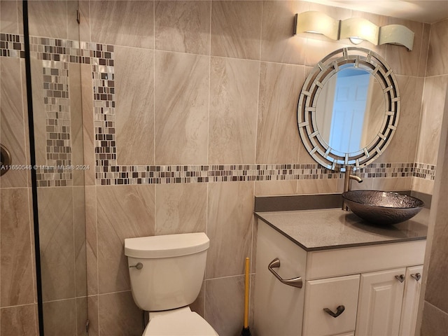 bathroom featuring vanity, tile walls, and toilet