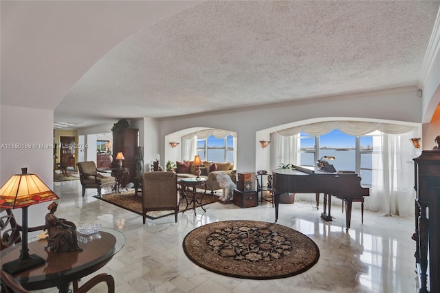 interior space with ornamental molding, a textured ceiling, a wealth of natural light, and a water view