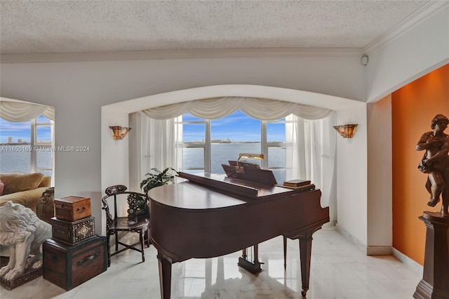 misc room with a textured ceiling, ornamental molding, and a water view