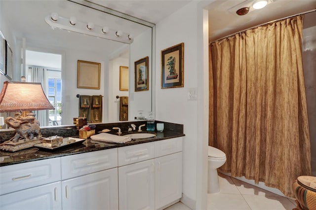 bathroom featuring vanity, toilet, tile patterned floors, and walk in shower