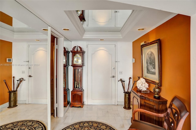 foyer entrance with a tray ceiling and crown molding