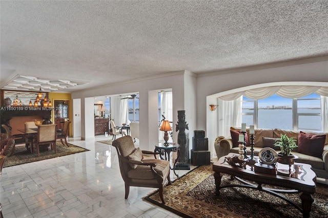 living room featuring a water view, ornamental molding, and a textured ceiling