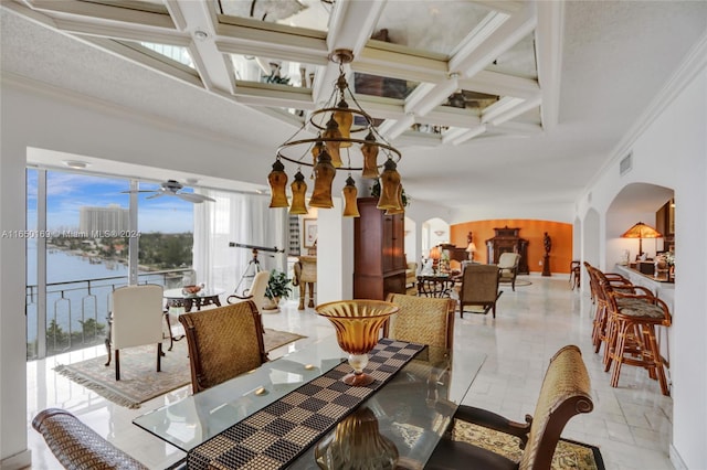 dining area featuring ceiling fan with notable chandelier, coffered ceiling, a water view, and ornamental molding