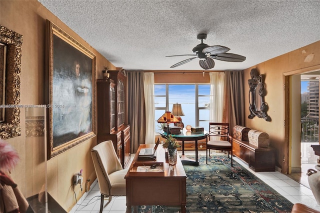 tiled dining area with a textured ceiling and ceiling fan