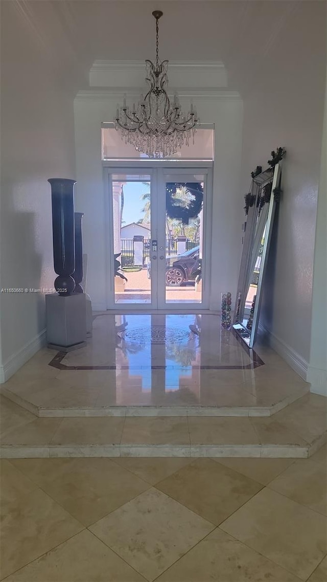 doorway with a notable chandelier, french doors, ornamental molding, and baseboards