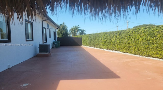 view of patio featuring central air condition unit and fence