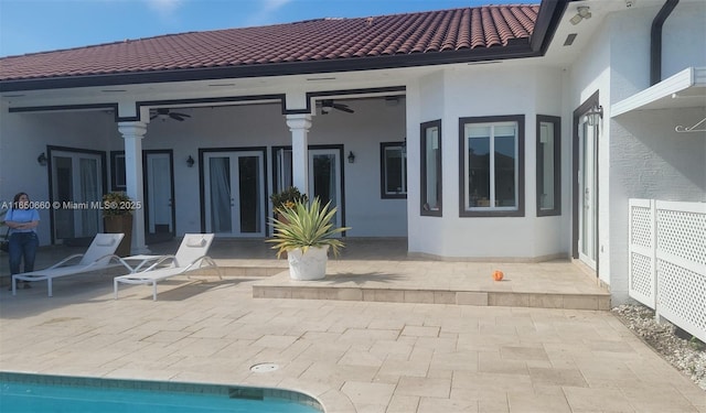 back of property featuring french doors, a tile roof, a patio, and stucco siding