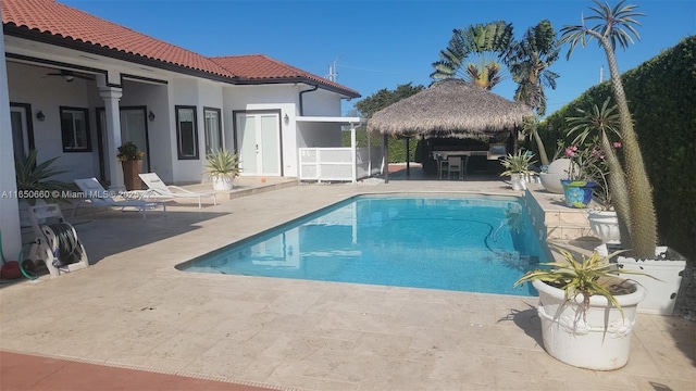 outdoor pool featuring a ceiling fan, a patio, a gazebo, and fence