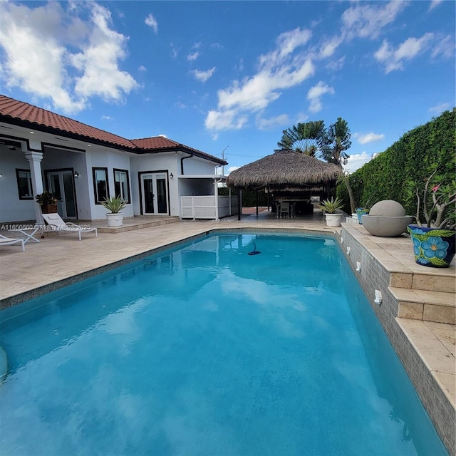 view of pool featuring a patio area, a gazebo, a fenced in pool, and french doors