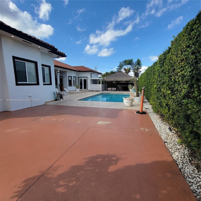 pool with a gazebo, a patio, and fence