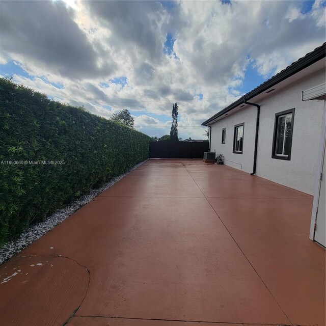 view of patio featuring central AC and fence